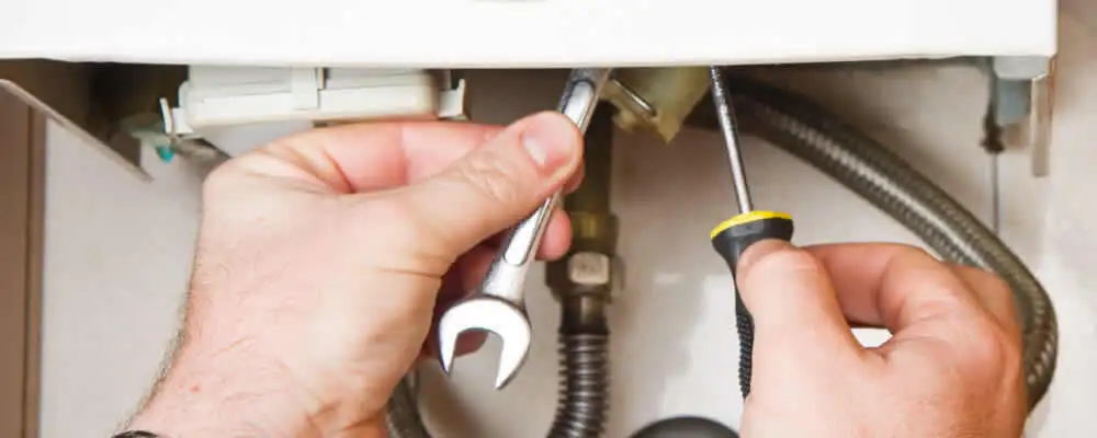 Boiler repair technician tightening pipe fittings and connections in Allentown, PA
