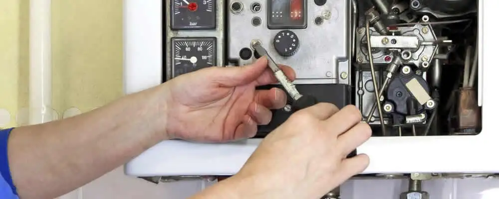 Heating repair technician adjusting boiler controls and components in Allentown, PA