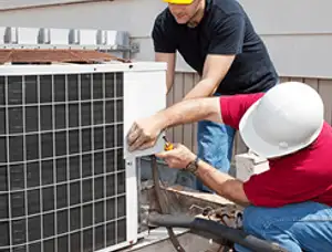 HVAC technicians repairing an outdoor AC unit on a rooftop in Allentown, PA