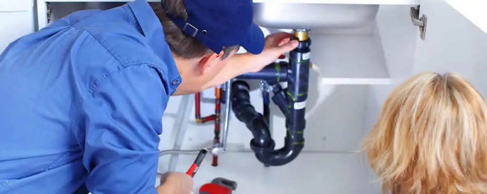 Plumber repairing under-sink drain pipes and fittings in Allentown, PA
